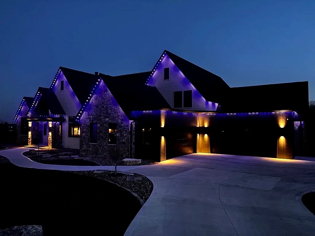 Purple roofline with warm downlights — permanent outdoor lighting installed by Buzz Lighting's crew